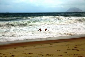 Люди купаются в шторм в Бразилии